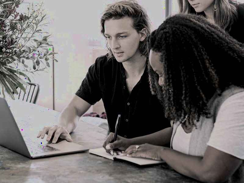 Experienced team member mentoring a new representative reviewing notes together
