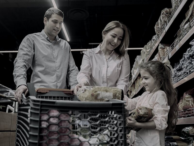 Family shopping together in a retail store aisle while comparing product options