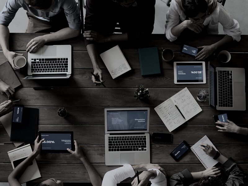 Overhead view of a team reviewing campaign performance on laptops and tablets